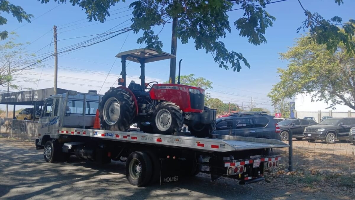 Transporte de tractor rojo sobre plataforma